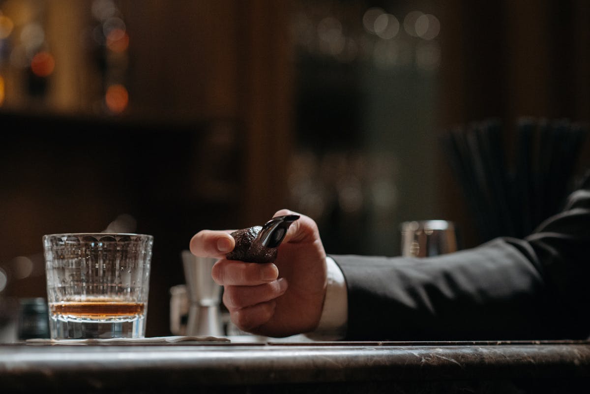 A tobacco pipe held at a bar counter